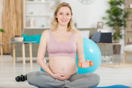 pregnant woman at the gym sitting by fitness ball isolated