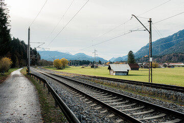 Railway Tracks through Bavarian Countryside with Alps in Background