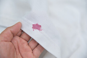 dirty pink cosmetic stain on white shirt in daily life. stain for cleaning concept.