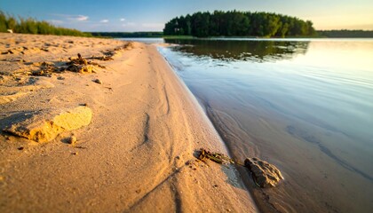 Sandy shoreline meets tranquil lake at sunset