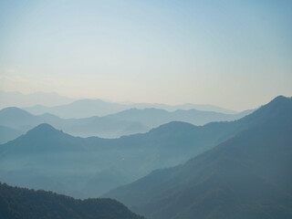 Silhouettes of a mountain range fading into the horizon.