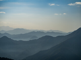 Silhouettes of a mountain range fading into the horizon.
