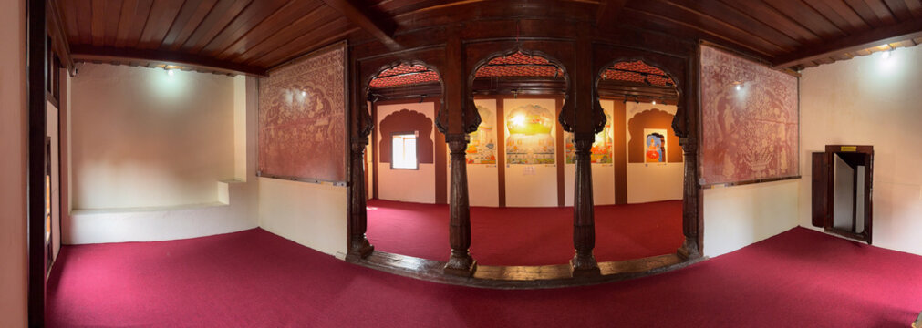 Traditional wooden-pillared hall inside Nana Fadnavis Wada, featuring preserved murals, red carpets, and classic Maratha architectural elements.