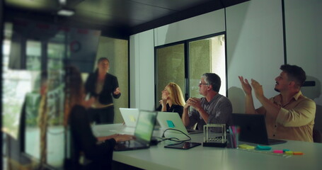 African American businesswoman answering questions during team presentation while colleagues engage...