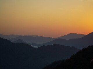 A mountain range at sunset with a golden sky.
