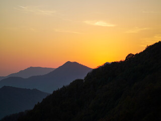 A mountain range at sunset with a golden sky.
