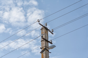 High-voltage power pole with wires against blue sky background, energy and nature