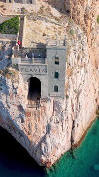  castle nestled on vertical cliffs above serene mediterranean coves near italy. Porto Flavia. vertical video