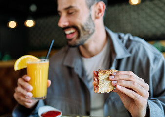 Young man enjoying eating lunch at restaurant