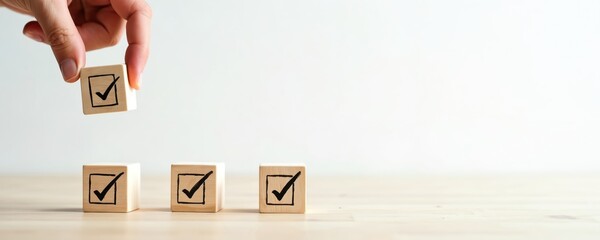 Hand places wooden cube with check mark onto blocks. Planning success, task completion, verification, goal achievement. Simple checklist concept for project management personal to-do lists.