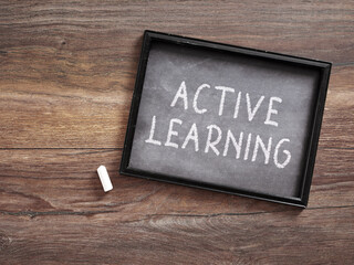 Active Learning Written on Small Chalkboard on Wooden Desk