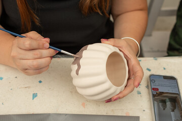 Detalle de manos pintando artesan&iacute;as