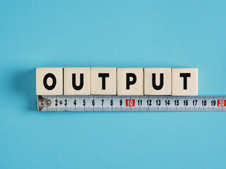 Measuring output: wooden cubes and measuring tape on blue background