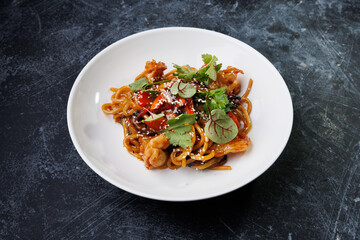 Spicy noodles with chicken, peppers, fresh herbs, and sesame seeds