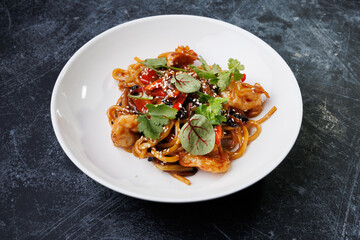 Spicy noodles with chicken, peppers, fresh herbs, and sesame seeds