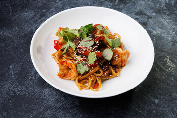 Spicy noodles with chicken, peppers, fresh herbs, and sesame seeds