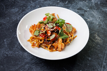 Spicy noodles with chicken, peppers, fresh herbs, and sesame seeds