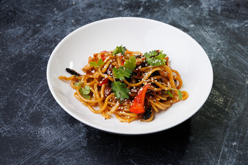 Spicy noodles with chicken, peppers, fresh herbs, and sesame seeds