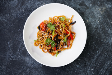 Spicy noodles with chicken, peppers, fresh herbs, and sesame seeds