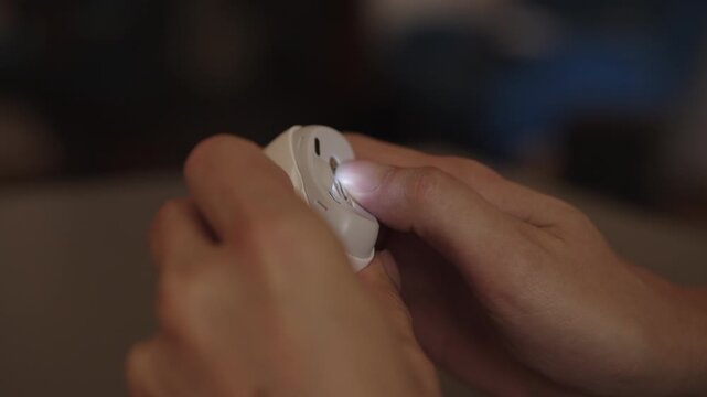 Male operating modern electronic nail file, carefully trimming fingernails for precise shaping, emphasizing personal care, hygiene and home manicure routine, close-up. Shooting in slow motion.