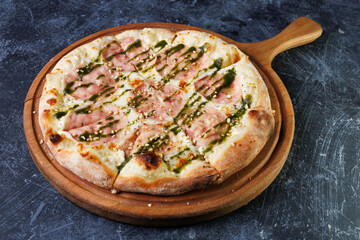 Wooden Board Pizza With Ham, Mozzarella, and Pesto Drizzle