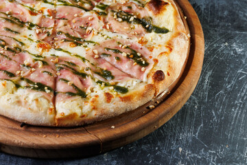 Wooden Board Pizza With Ham, Mozzarella, and Pesto Drizzle