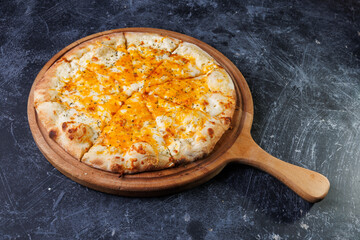 Cheesy Baked Pizza On Wooden Paddle Served On Dark Textured Tabletop