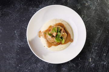 Gourmet Plate With Creamy Puree, Tender Meat, And Herb Garnish