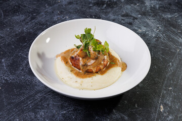Gourmet Plate With Creamy Puree, Tender Meat, And Herb Garnish