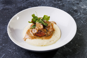 Gourmet Plate With Creamy Puree, Tender Meat, And Herb Garnish