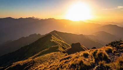 A breathtaking view of layered mountain ranges bathed in the warm, golden light of a sunrise.