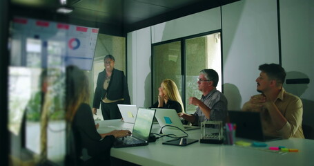 African American presenter smiling after delivering business presentation while colleagues respond positively in team meeting environment