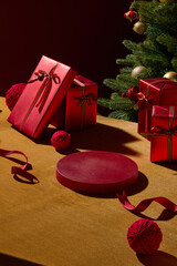 Red Christmas gifts placed on a wooden surface with soft warm light. The simple composition creates...