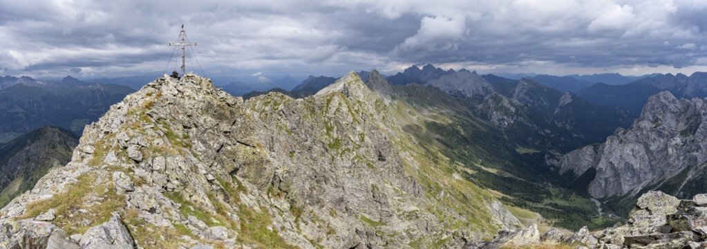 Rocky, pointed summit of the Raudenspitze or Monte Fleons with summit cross, view of the Val Fleons mountain panorama on the Carnic main ridge, Carnic Alps, Carinthia, Austria