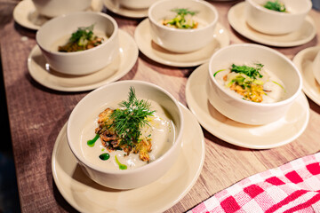 A table with several white bowls of food on plates