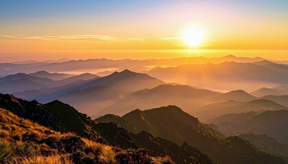 A breathtaking sunrise casts a golden glow over layers of misty mountain peaks, creating a serene and majestic landscape.