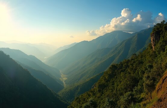 Beautiful mountain landscape view from Ella Gap. Green hills and deep valley covered with jungle forest. Sun shines over foggy mountains, creates golden haze. A famous Sri Lanka travel destination. - Powered by Adobe
