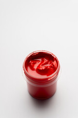 Close-up of colorful paints. Red paint on a white background. Space for drawing