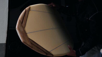 Expert surfboard shaping techniques demonstrated by skilled shaper in workshop - Powered by Adobe