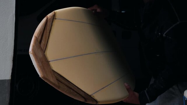 Expert surfboard shaping techniques demonstrated by skilled shaper in workshop