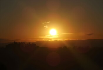 Golden sunset over rolling hills, warm light fills the sky