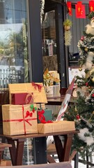 Stack of Festive Holiday Gifts Wrapped in Paper on Display by Christmas Tree