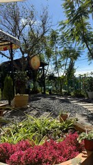 Sunny Outdoor Cafe or Garden Seating Area with Lush Greenery and Gravel Ground