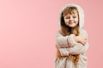 Cute girl in bathrobe on pink background. Space for text