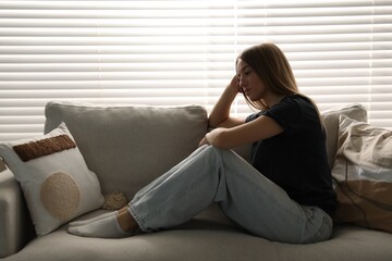 Fototapeta premium Depressed teenage girl on sofa at home