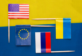 The flags of Ukraine, the USA, the EU, and Russia against the background of the Ukrainian flag