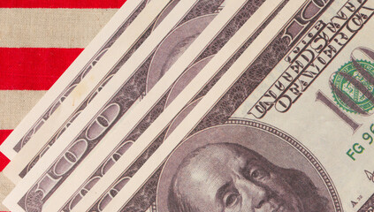 One hundred US dollars against the background of the US flag