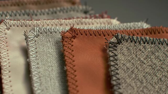 Fabric swatches with stitched edges against a grey backdrop for color selection
