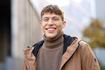 Portrait of smiling man in glasses on city street