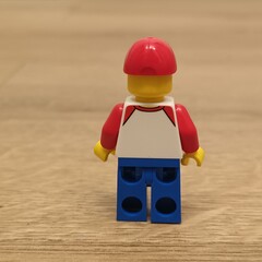 Fototapeta premium Rear view of a Lego figure wearing a red cap and white shirt, representing childhood memories and play